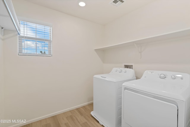 laundry area featuring visible vents, baseboards, washing machine and dryer, laundry area, and light wood-style floors