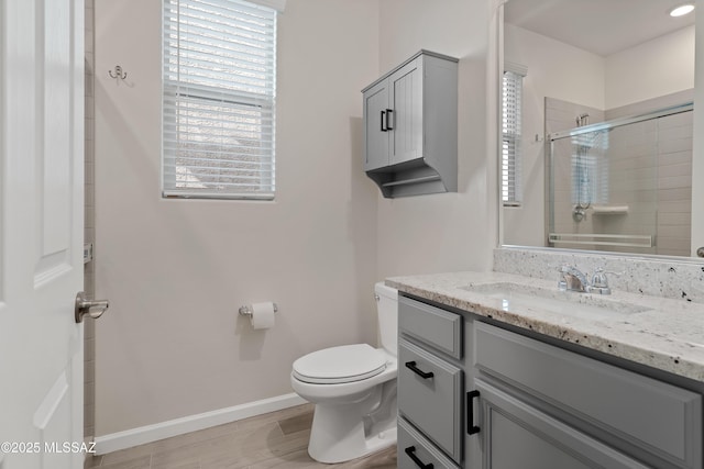 full bath with plenty of natural light, a shower stall, toilet, and vanity