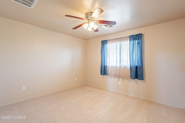 spare room with baseboards, ceiling fan, visible vents, and light colored carpet