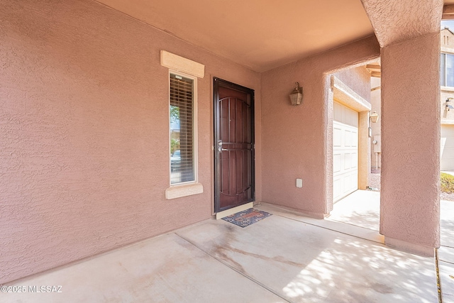 property entrance featuring stucco siding and a garage
