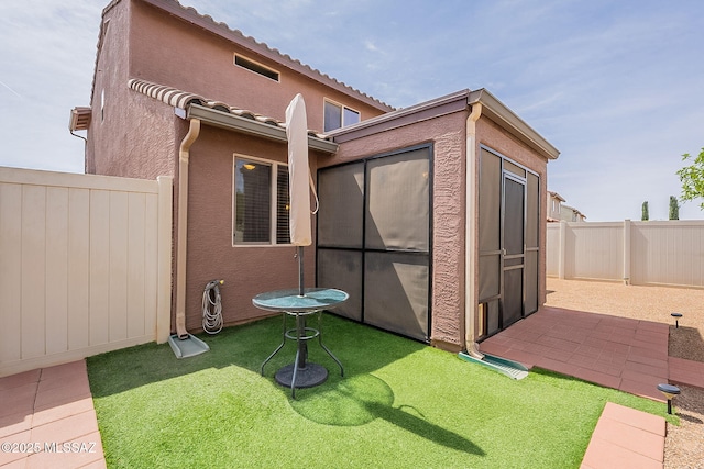 exterior space with a fenced backyard, stucco siding, and a yard