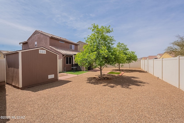 view of yard featuring a fenced backyard, an outbuilding, and a shed