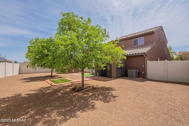 back of property featuring a tiled roof, central AC, a fenced backyard, stucco siding, and a patio area