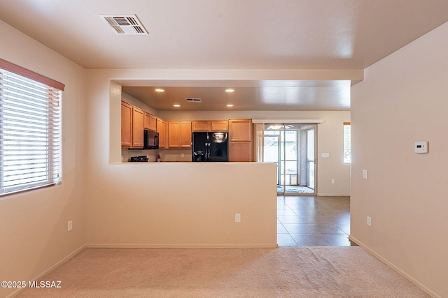 kitchen featuring visible vents, black appliances, plenty of natural light, and light carpet