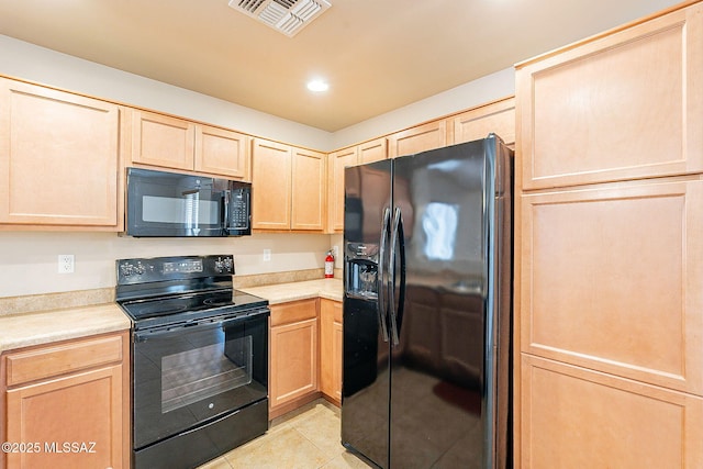 kitchen with visible vents, light countertops, black appliances, and light brown cabinetry