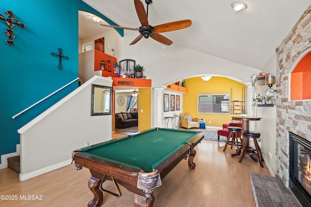 game room featuring pool table, ornate columns, a fireplace, arched walkways, and a ceiling fan