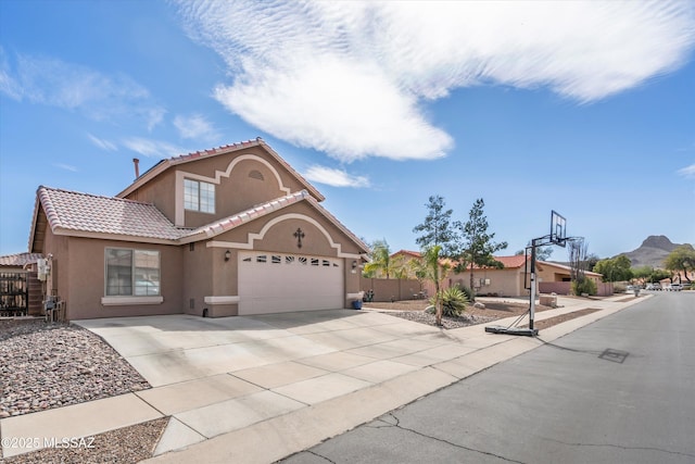 mediterranean / spanish-style house featuring fence, concrete driveway, a tile roof, stucco siding, and an attached garage