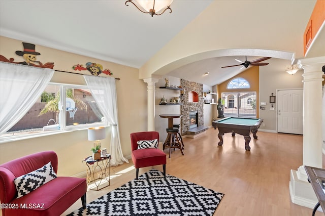 interior space featuring wood finished floors, pool table, a fireplace, decorative columns, and ceiling fan