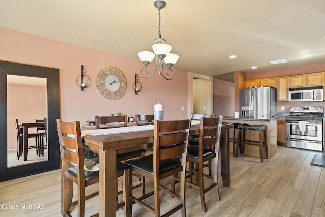 dining space with visible vents, light wood-style floors, recessed lighting, and an inviting chandelier