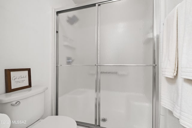 full bath with toilet and a stall shower
