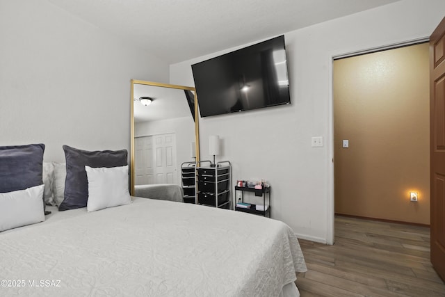bedroom with baseboards, a closet, and wood finished floors