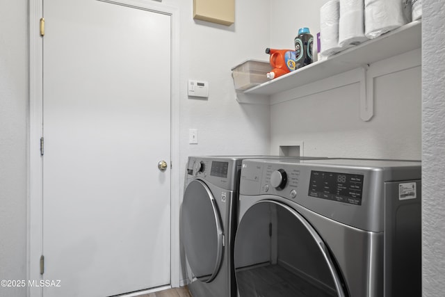 clothes washing area featuring wood finished floors, laundry area, and separate washer and dryer