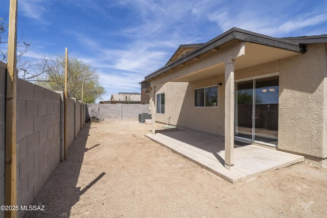 view of yard with a fenced backyard, central air condition unit, and a patio