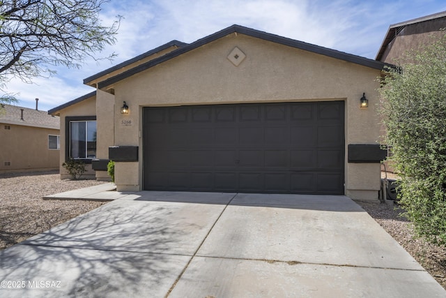 ranch-style home with driveway, stucco siding, and a garage