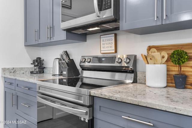 kitchen featuring light stone counters, appliances with stainless steel finishes, and gray cabinets