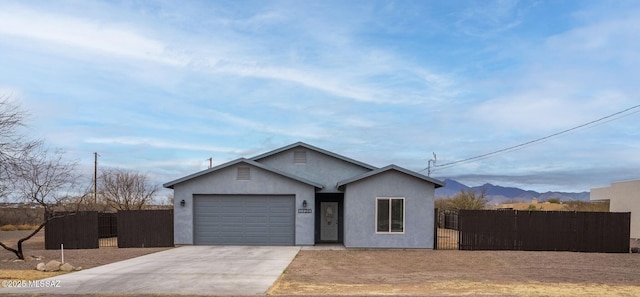 view of front of house with a gate, fence, driveway, stucco siding, and a garage