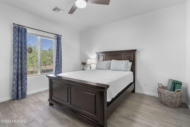 bedroom featuring visible vents, ceiling fan, baseboards, and wood finish floors