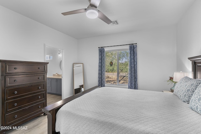 bedroom featuring visible vents, ensuite bath, ceiling fan, and light wood finished floors