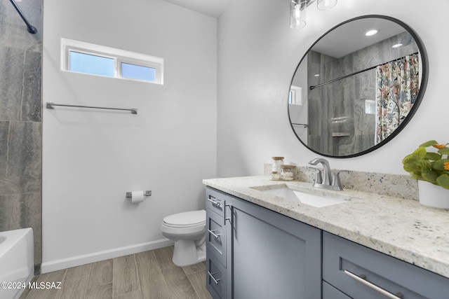 bathroom with toilet, vanity, baseboards, and wood finished floors