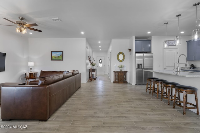 living room featuring recessed lighting, a ceiling fan, visible vents, and wood finish floors