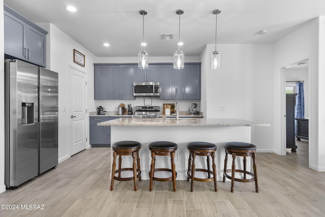 kitchen featuring a sink, a breakfast bar area, visible vents, and stainless steel appliances