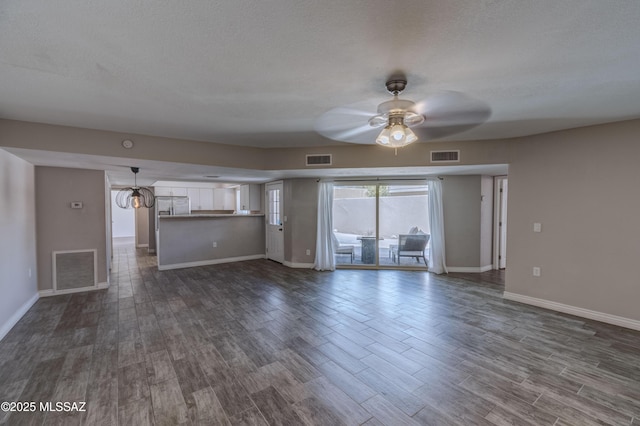 unfurnished living room with visible vents, dark wood finished floors, and a ceiling fan