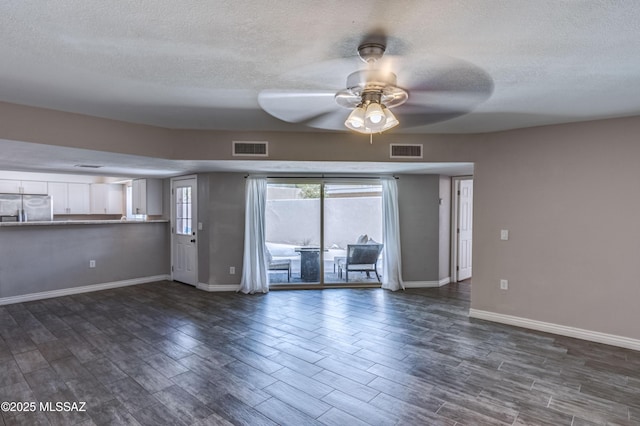 unfurnished living room featuring dark wood-style floors, visible vents, baseboards, and ceiling fan