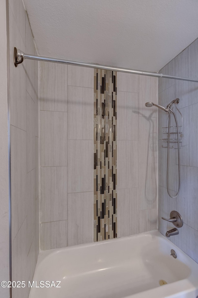 full bath with a textured ceiling and shower / tub combination