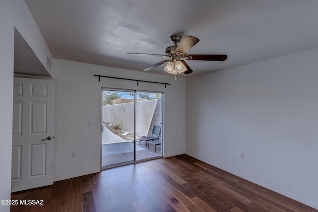 empty room featuring wood finished floors, a ceiling fan, and visible vents