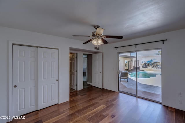 unfurnished bedroom featuring ceiling fan, visible vents, wood finished floors, and access to outside