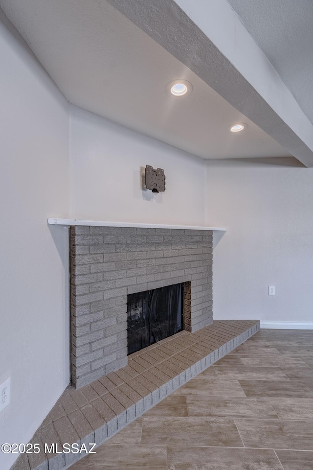 interior details with wood finished floors, a brick fireplace, recessed lighting, and baseboards