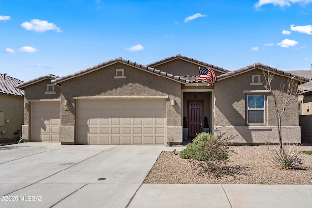 view of front of property featuring a tile roof, concrete driveway, a garage, and stucco siding