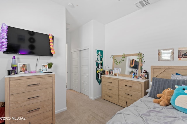 bedroom featuring baseboards, visible vents, light carpet, and a closet