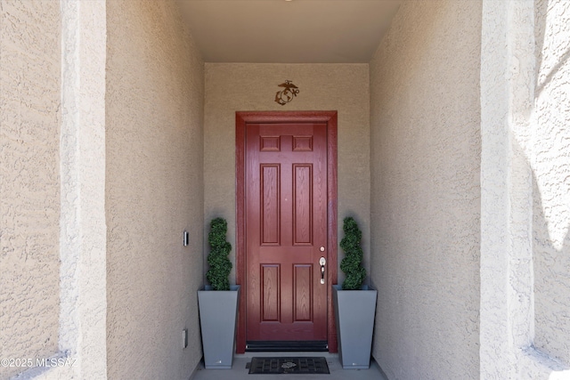 property entrance with stucco siding