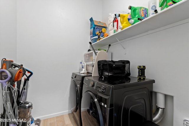 laundry room featuring laundry area, light wood-style flooring, baseboards, and washing machine and clothes dryer