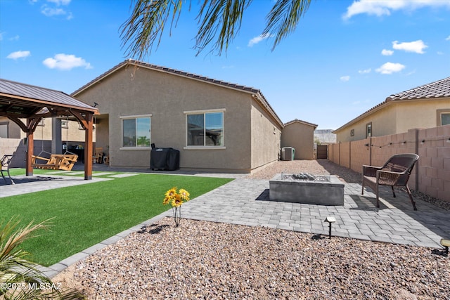 back of house featuring a gazebo, stucco siding, an outdoor fire pit, and a patio