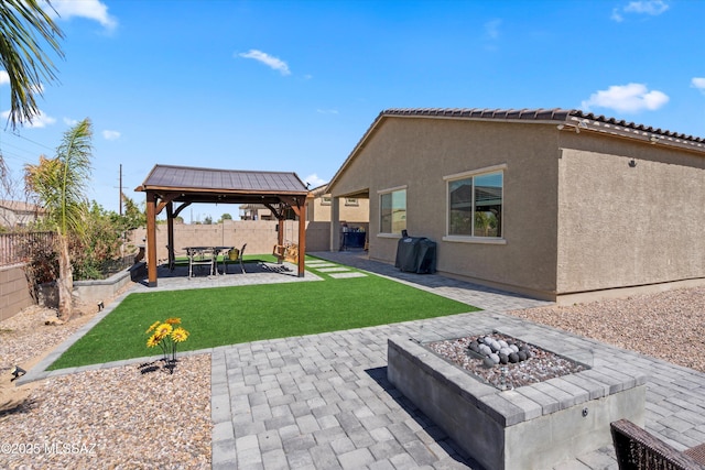 exterior space with a gazebo, an outdoor fire pit, and a fenced backyard