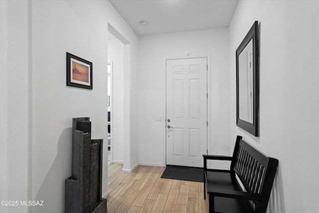 foyer entrance with baseboards and light wood-style floors