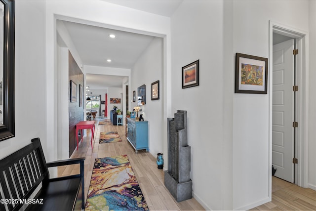 corridor featuring light wood finished floors, recessed lighting, and baseboards