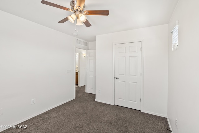 unfurnished bedroom featuring dark colored carpet, visible vents, baseboards, and ceiling fan