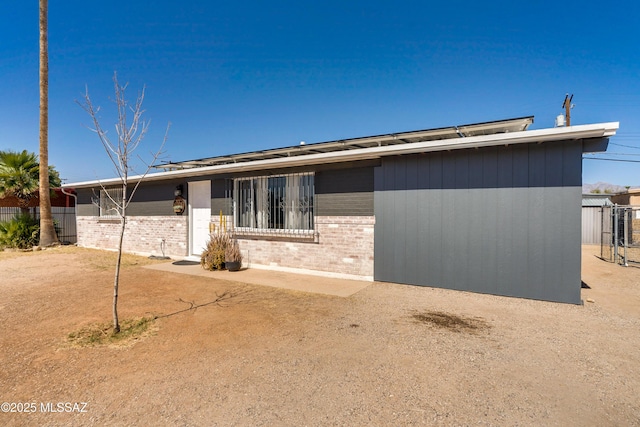 mid-century modern home with fence and brick siding