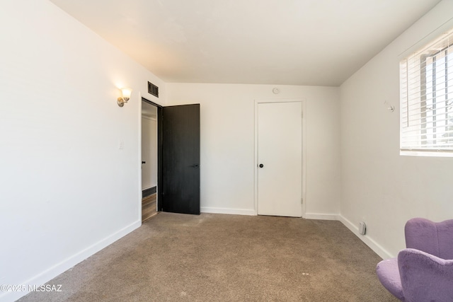 unfurnished bedroom with baseboards, carpet floors, and visible vents