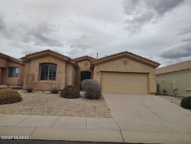 mediterranean / spanish-style home featuring stucco siding, an attached garage, and concrete driveway