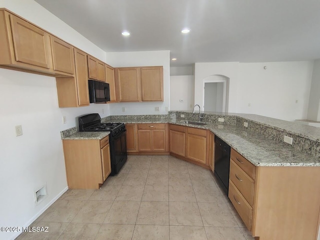 kitchen featuring light stone countertops, recessed lighting, arched walkways, a sink, and black appliances