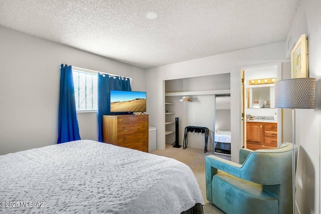 bedroom featuring a closet, a textured ceiling, carpet, and connected bathroom