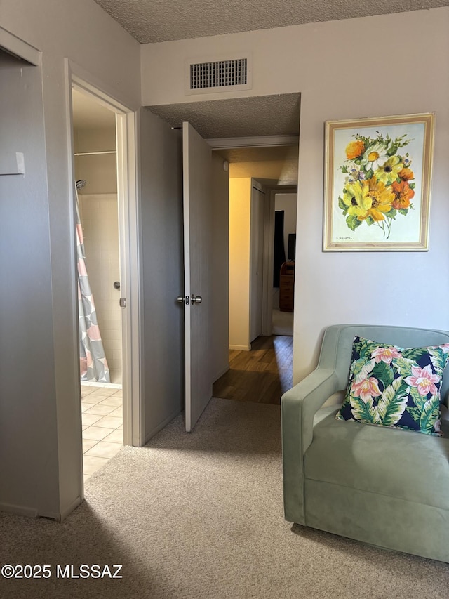 carpeted living room with visible vents and a textured ceiling
