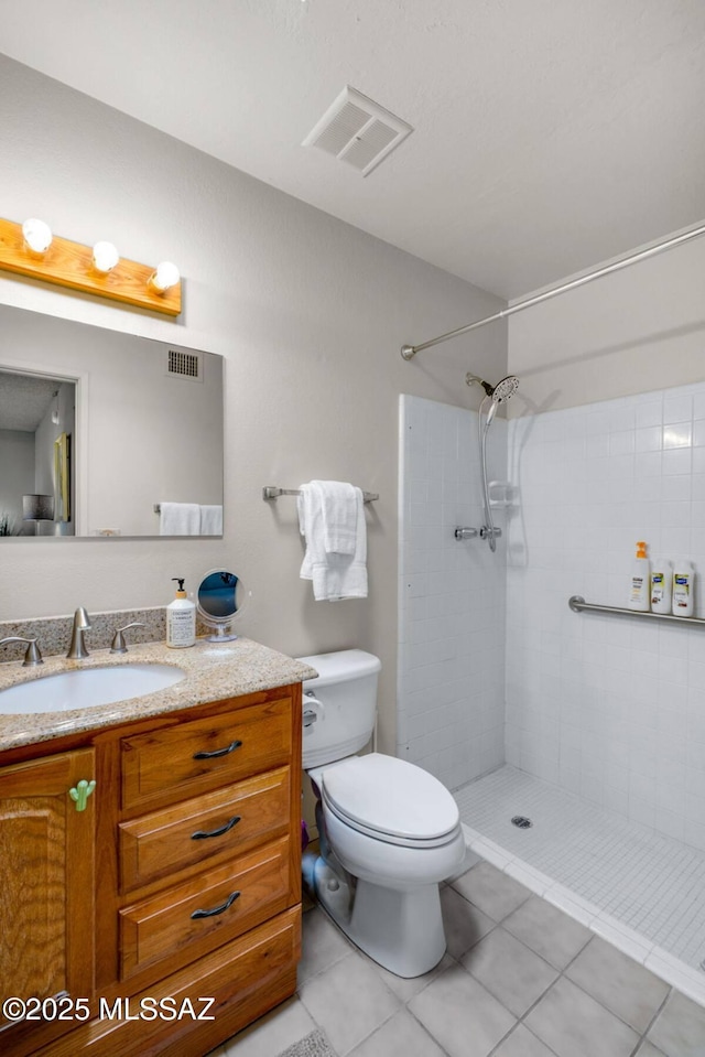full bathroom featuring visible vents, tile patterned flooring, vanity, toilet, and tiled shower