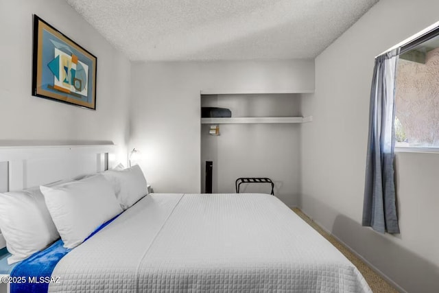 bedroom featuring carpet flooring and a textured ceiling
