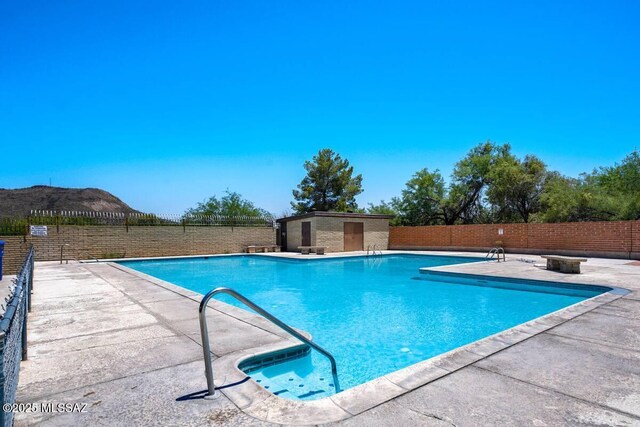 pool featuring a patio area, fence, and a mountain view