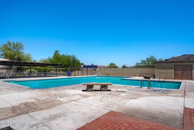 community pool featuring fence and a patio area